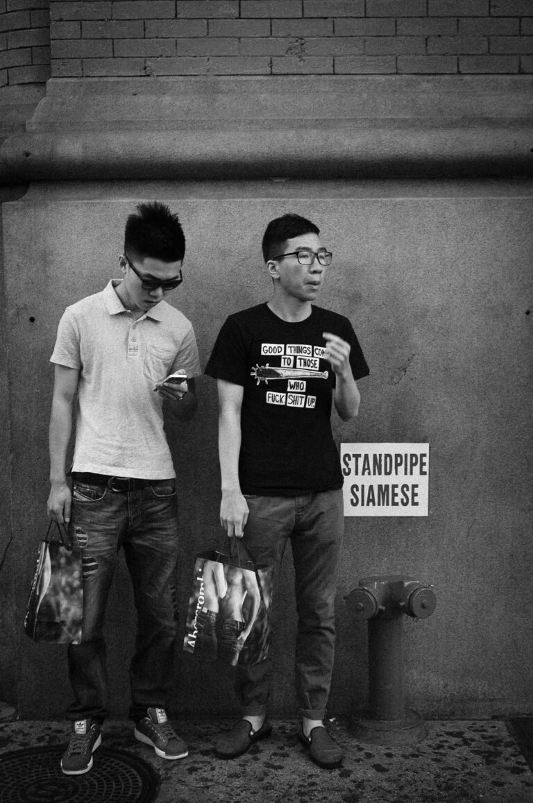 Street photography -henkinen dokumentaarinen kuva New Yorkista, kaksi nuorta miest&auml; shoppailemassa