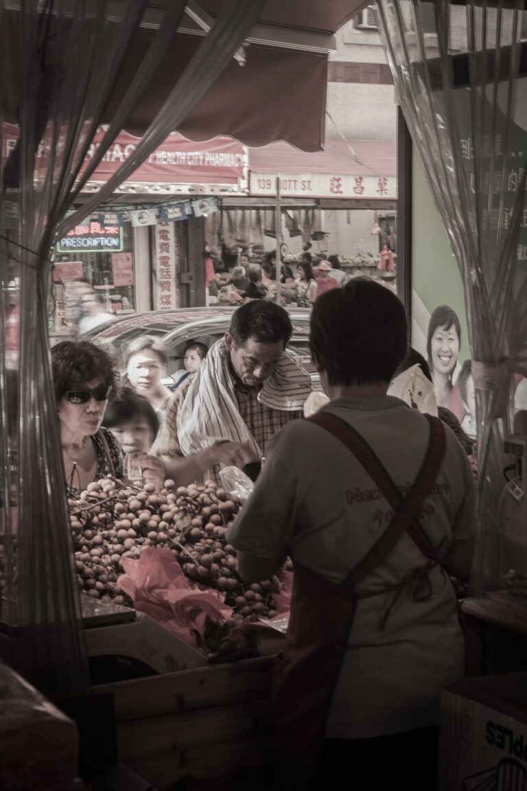 Street photography -henkinen dokumentaarinen kuva Chinatownista New Yorkissa, asiakkaat ostoksilla kadunvarsikojulla